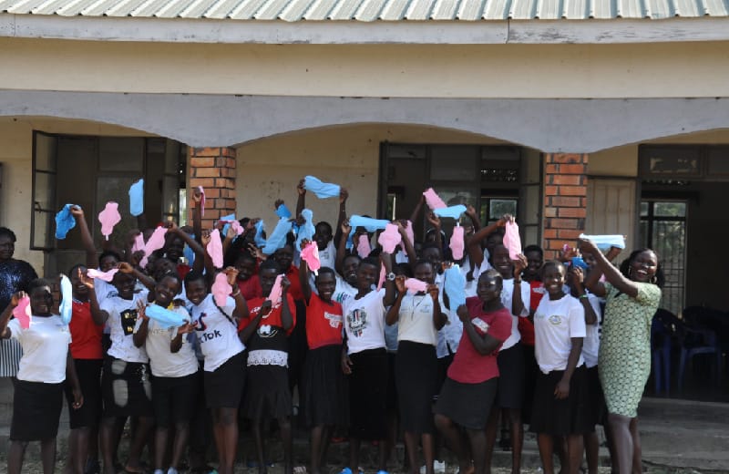 Girls from Nebbi showing the reusable pads they made after completing social survival training 